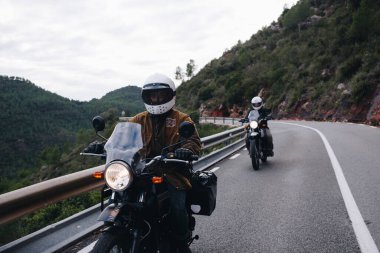 Dağ yolunda bir grup motosikletli.