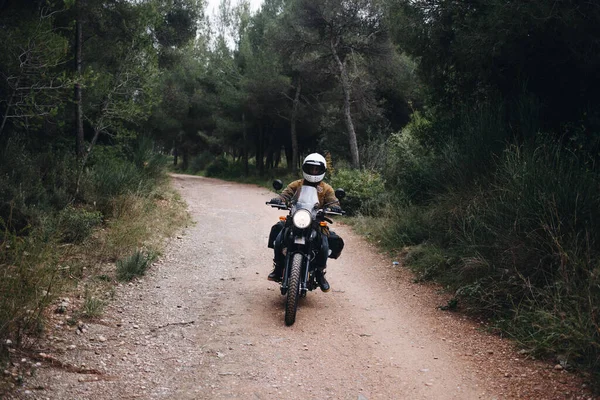 Single motorcycle rider on dirt road in forest — Stock Photo, Image