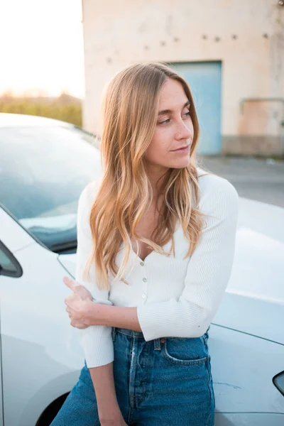 Millennial female teenager stand next to white car — Stock fotografie