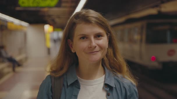 Молодая женщина на станции метро в коронавирусной маске — стоковое видео