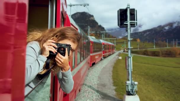 Щаслива жінка-фотограф на швейцарському поїзді — стокове відео