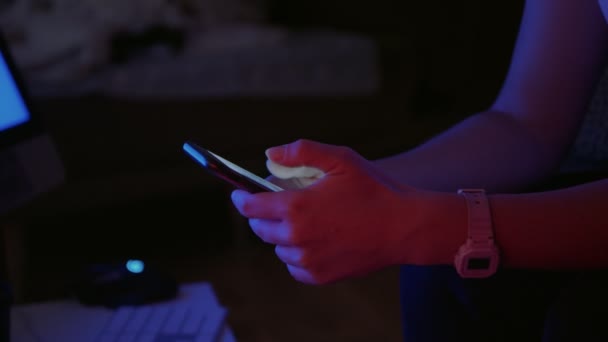 Mujer sostiene teléfono inteligente en la noche en luz de neón — Vídeos de Stock