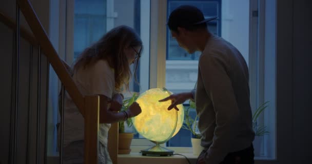 Jong stel kijk op kaart globe plan nieuwe vakantie — Stockvideo