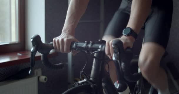 Treinamento de homem adulto em treinador de bicicleta inteligente indoor — Vídeo de Stock
