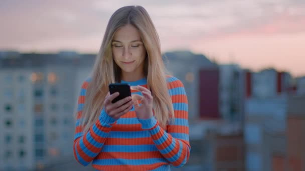 Joven milenaria uso de teléfono inteligente al atardecer — Vídeos de Stock