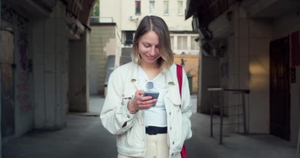 Linda auténtica joven uso de teléfono inteligente riendo — Vídeo de stock