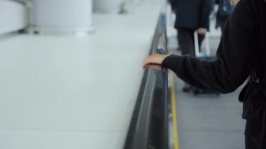 Havaalanındaki kadın kaldırım kenarındaki rayları tutun.