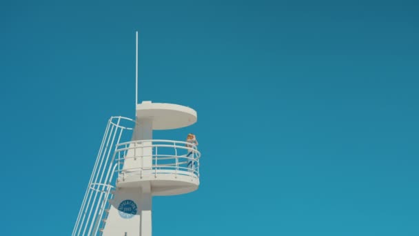 Girl in beach lifeguard tower on isolated blue sky — Stock Footage Girl in beach lifeguard tower on isolated blue sky Stock Footage