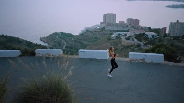 Strong fit female athlete run over city at sunrise — Stock Video