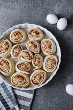 Tarçın fırından önce bir kabın içinde yuvarlanır. Çiğ ekmek kabında yuvarlanıyor..