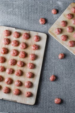 Kesme tahtasında çiğ köfteler var.