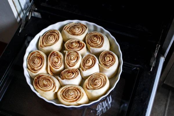 Tarçın fırından önce bir kabın içinde yuvarlanır. Çiğ ekmek kabında yuvarlanıyor..