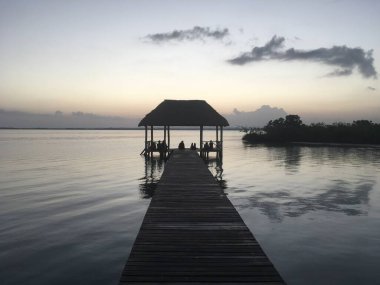 Temiz su ile güzel okyanus manzarası, akşam ya da gece adanın inanılmaz arka planı, Karayipler, Lagoon Bacalar. Sakin, tenha bir yer. İnsanlar gün batımıyla, cennetle tanışır.
