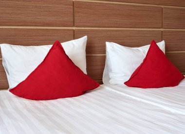 Odada kırmızı yastıklar olan güzel bir yatak.