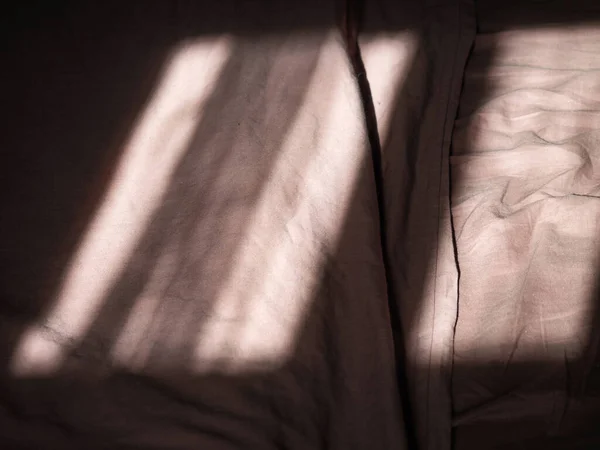 아침 햇살을 받으며 침대에 누워 있는 아름다운 그림자 — 스톡 사진