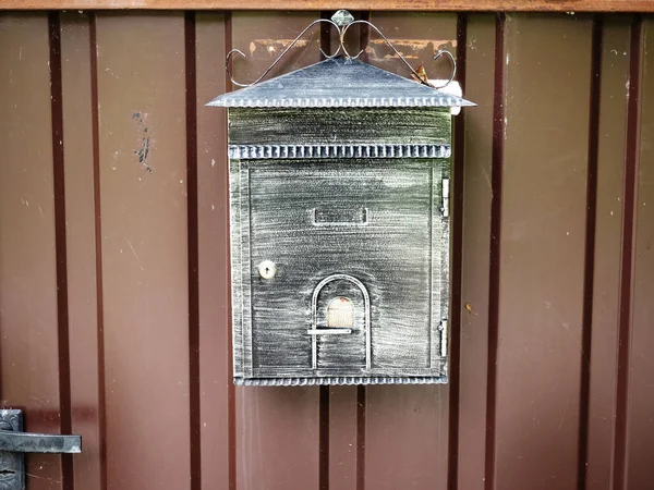 Patina mailbox hanging on a brown iron door — Stock Photo, Image