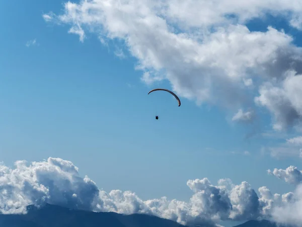 Paraglider flying far in the sky against the background of clouds — Stock Photo, Image