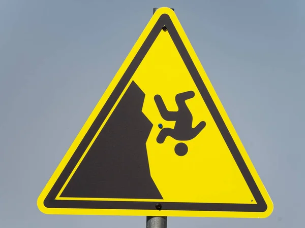 Yellow triangular hazard warning sign on a gray background — 스톡 사진