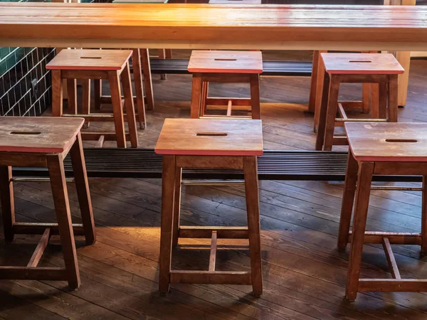 Houten krukken op een houten vloer aan weerszijden van de tafel — Stockfoto