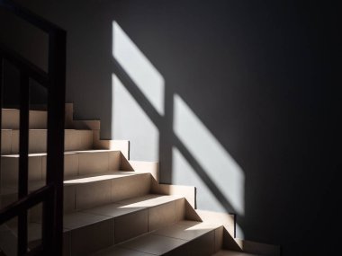 Photos of light steps and gray wall partially illuminated by the sun from the window and with the falling shadow