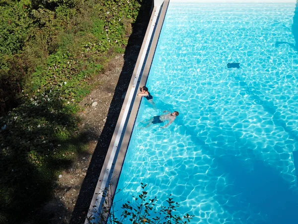 Sochi, Rusia - 13 de octubre de 2019. Hombre y mujer nadando en una piscina de agua azul clara al aire libre — Foto de Stock