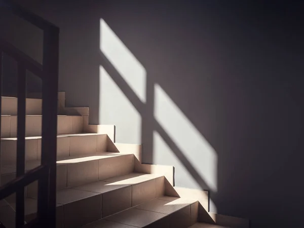 View of the bright steps illuminated by the sun and with a reflecting window in the form of a shadow on the wall — Zdjęcie stockowe