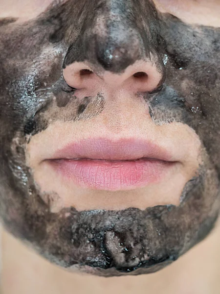 Γκρο πλαν φωτογραφία του κάτω μέρους ενός γυναικείου προσώπου με μαύρη φλούδα από τη μάσκα — Φωτογραφία Αρχείου