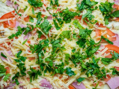 Jambon dilimleri, rendelenmiş domates peyniri ve doğranmış yeşillik ile pişirme yemeği için hazır.