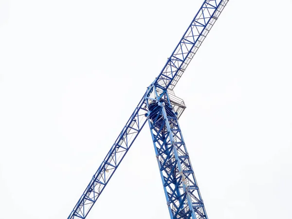 Lange blauwe torenkraan voor het bouwen van huizen op een bewolkte hemel achtergrond — Stockfoto