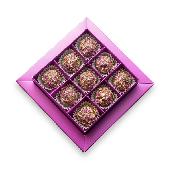 Purple box with round sweets sprinkled with dry rose petals on an isolated background — Stock Photo, Image