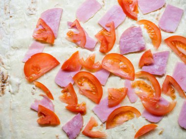 Lavaş yağlı mayonez, jambon dilimleri ve domates dilimleri.