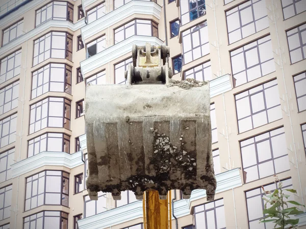 Photo of a dirty excavator bucket on the background of a new beautiful beige house — Stock Photo, Image