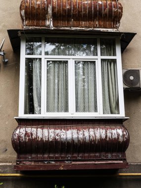 Yeni pencereleri olan eski bir apartmanda balkon kahverengisi.