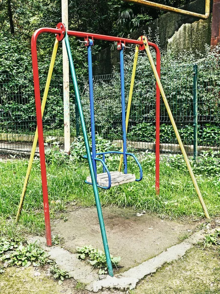 Barnens färgade gunga i lekplatsen på gatan — Stockfoto