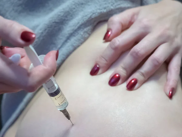 Het meisje maakt een therapeutische injectie met een injectiespuit in de billen — Stockfoto