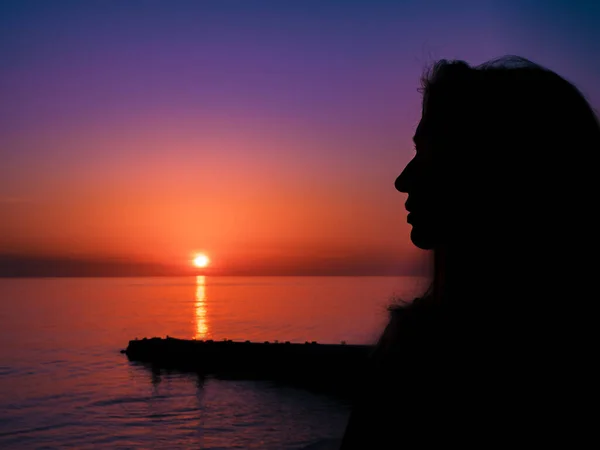 Siluetti tyttö taustaa vasten kaunis meri auringonlasku — kuvapankkivalokuva