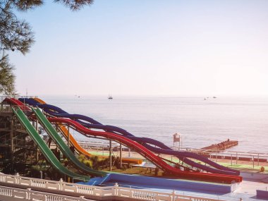 Denizin arka planındaki bir su parkında renkli slaytlar