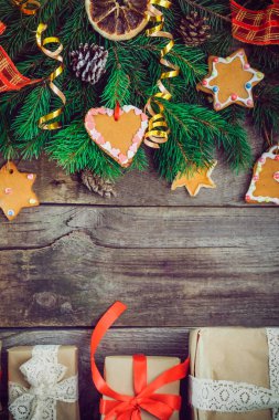 Vintage Noel arka plan ile çam dalları, yılbaşı dekor, zencefilli kurabiye, şekerlenmiş meyve, baharat ve hediye kutuları eski rustik ahşap zemin üzerinde. Üstten Görünüm kopya alanı ile. Seçici odak,