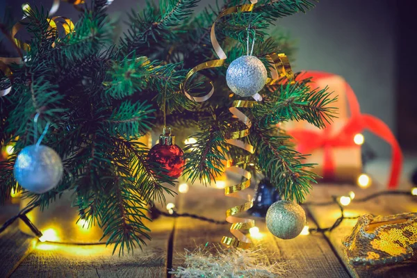 Composición de árbol de Navidad en jarrón con decoraciones, regalos y luces en la mesa vintage de madera. Fondo de Navidad estilo retro. Enfoque selectivo suave. Espacio para texto . — Foto de Stock