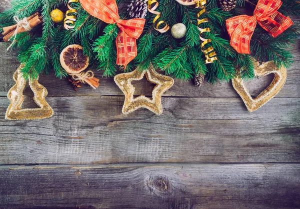 Fondo navideño vintage con ramas de abeto, decoración de año nuevo, juguetes, frutas confitadas y especias en el antiguo fondo rústico de madera. Vista superior con espacio de copia. Enfoque selectivo , — Foto de Stock