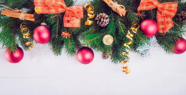 Noel arka plan ile çam dalları, yılbaşı dekor, oyuncak ve baharat beyaz ahşap zemin üzerinde. Üstten Görünüm kopya alanı ile. Seçici odak, geniş başlık biçimi