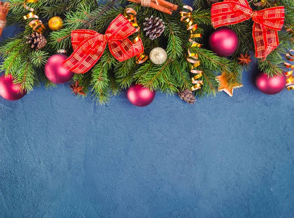 Fondo de navidad azul oscuro con ramas de abeto y decoración de año nuevo y juguetes en un fondo de pizarra o piedra. Vista superior con espacio de copia. Enfoque selectivo — Foto de Stock