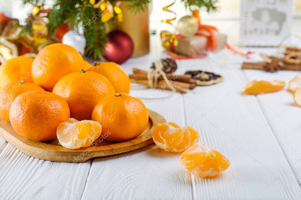 Christmas concept with Tangerines, Fir branches with decor , gifts and spices on the white wooden table. New year background. Selective focus. Space for text