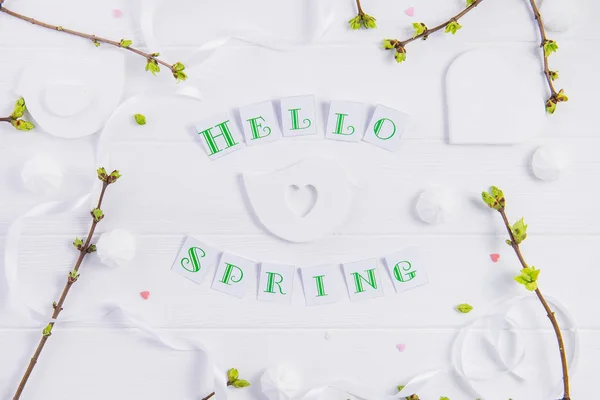 Jednoduché složení Hello jaro kaligrafie písma a větve s mladými výhonky zeleně na dřevěné pozadí. Koncepce umění. Selektivní fokus. Pohled shora. Prostor pro text. — Stock fotografie