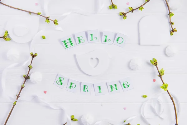 Composition simple de Hello Spring calligraphie lettrage et branches avec de jeunes pousses de verdure sur fond bois. Concept d'art. Concentration sélective. Vue de dessus. Espace pour le texte . — Photo