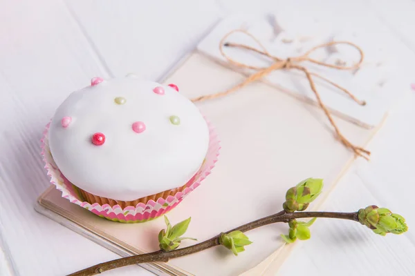 Húsvéti ünnep összetétele díszített cupcake, növényzet és kézműves Jegyzetfüzet-val üres fa háttér empy ága a fiatal hajtások. Művészeti koncepció. Szelektív összpontosít. — Stock Fotó
