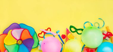 Üstten Görünüm parlak parti araçları ve dekorasyon - baloons, komik karnaval maske, Sarı zemin üzerine Festival gelin teli. Mutlu doğum günü tebrik kartı. Tasarım konsepti. Metin için yer. Geniş format.