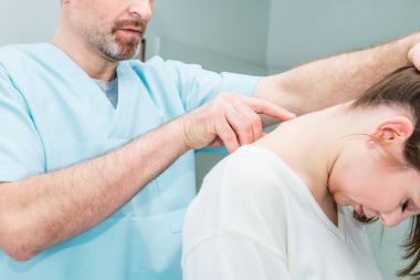 Erkek nörolog doktor yakından sağlık Kliniği kadın hasta spinal sütunda servikal vertebra inceliyor. Nörolojik muayene. Osteopati, chiropractic, Fizyoterapi.