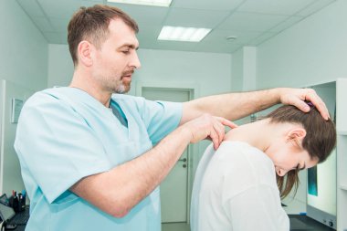 Erkek nörolog doktor sağlık Kliniği kadın hasta spinal sütunda servikal vertebra inceliyor. Nörolojik muayene. Osteopati, chiropractic, Fizyoterapi. Seçici odak.