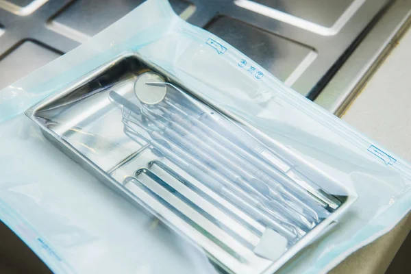 Close up sterilized packaged dentist instruments. Sterility and safety care concept. Selective focus, space for text. — Stock Photo, Image